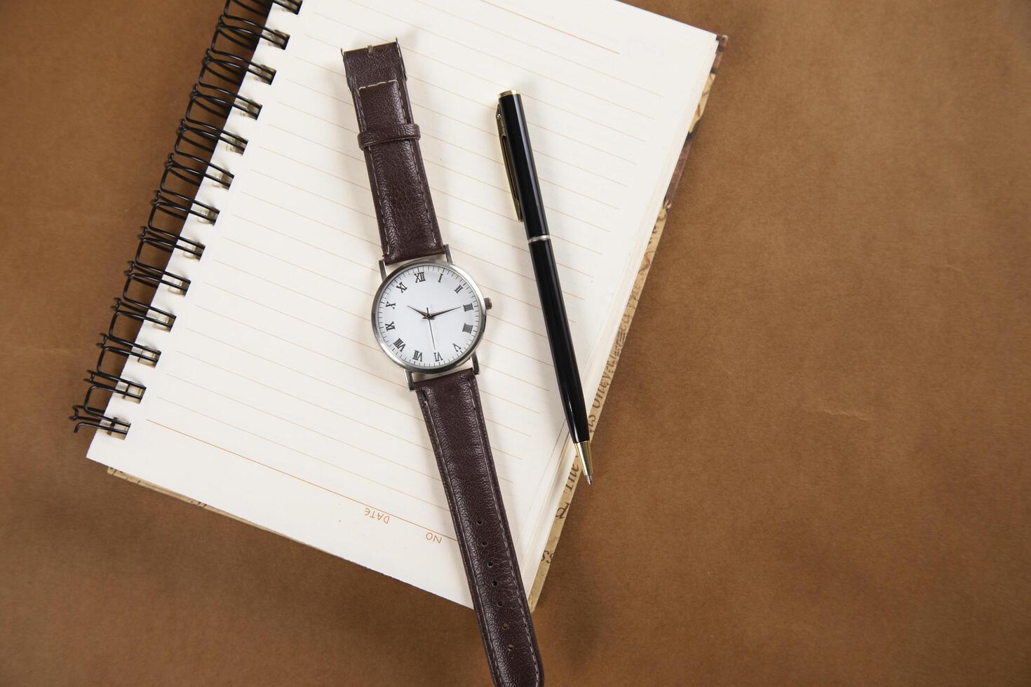 watch and pen on notepad photo
