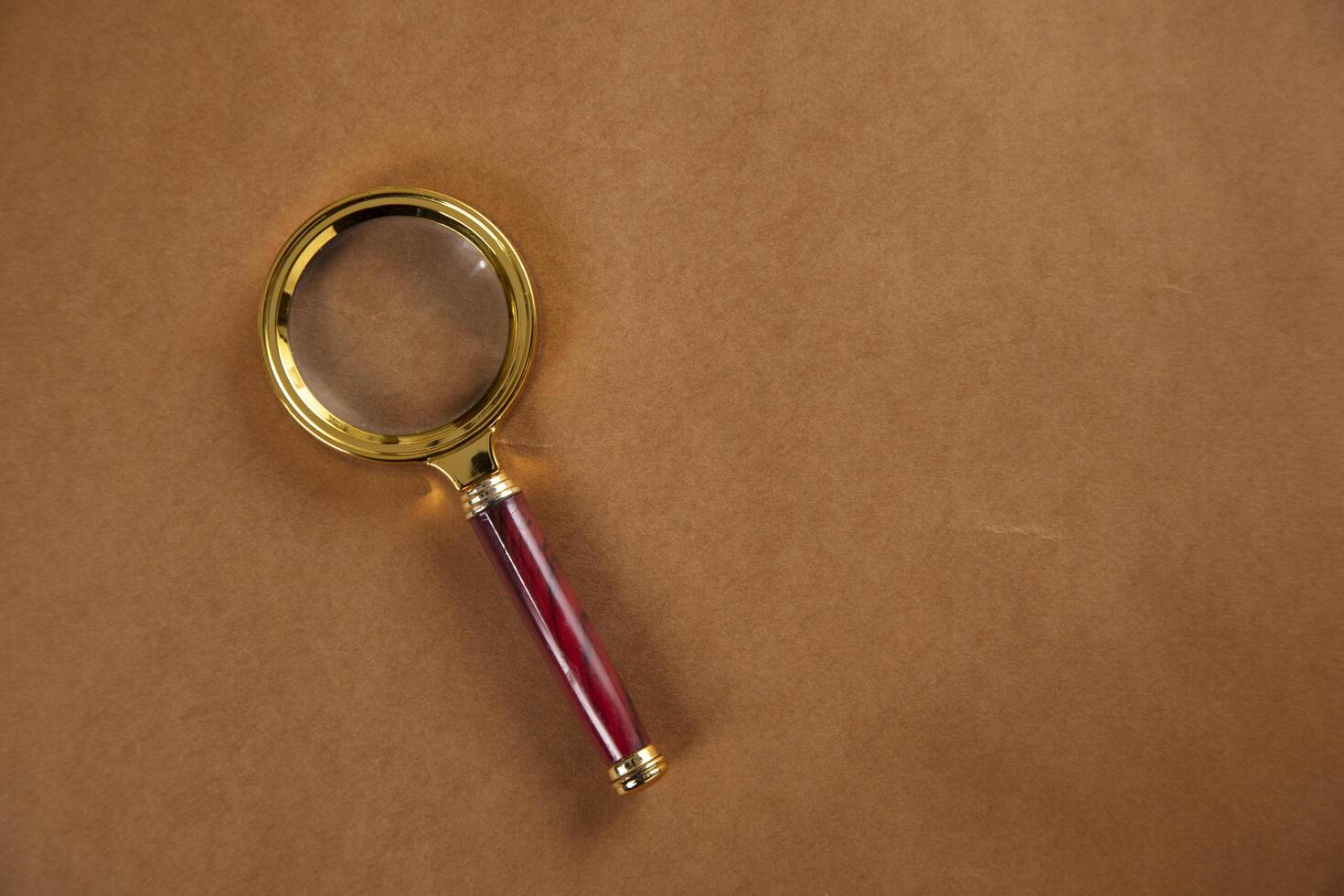 magnifying glass on brown background photo