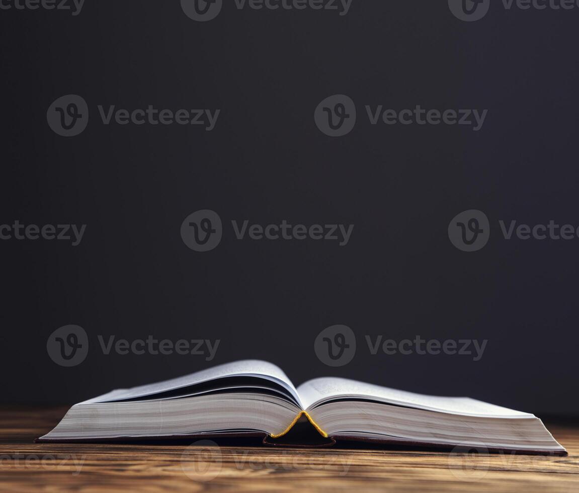 open antique book on wooden photo