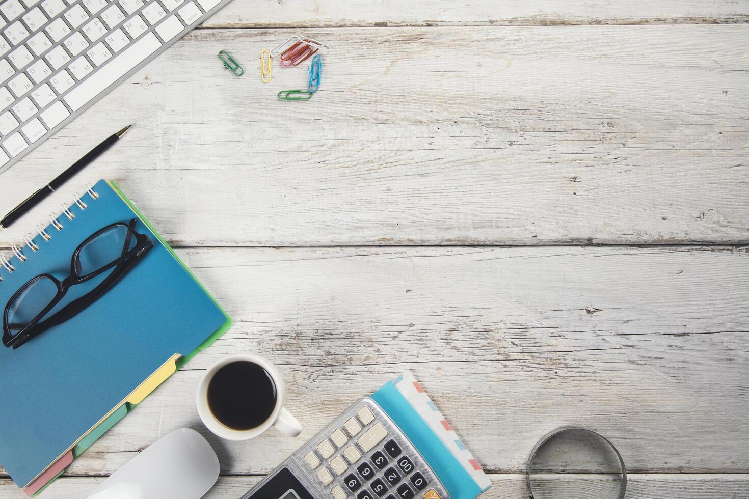 A desk with a keyboard, mouse, and a notebook photo
