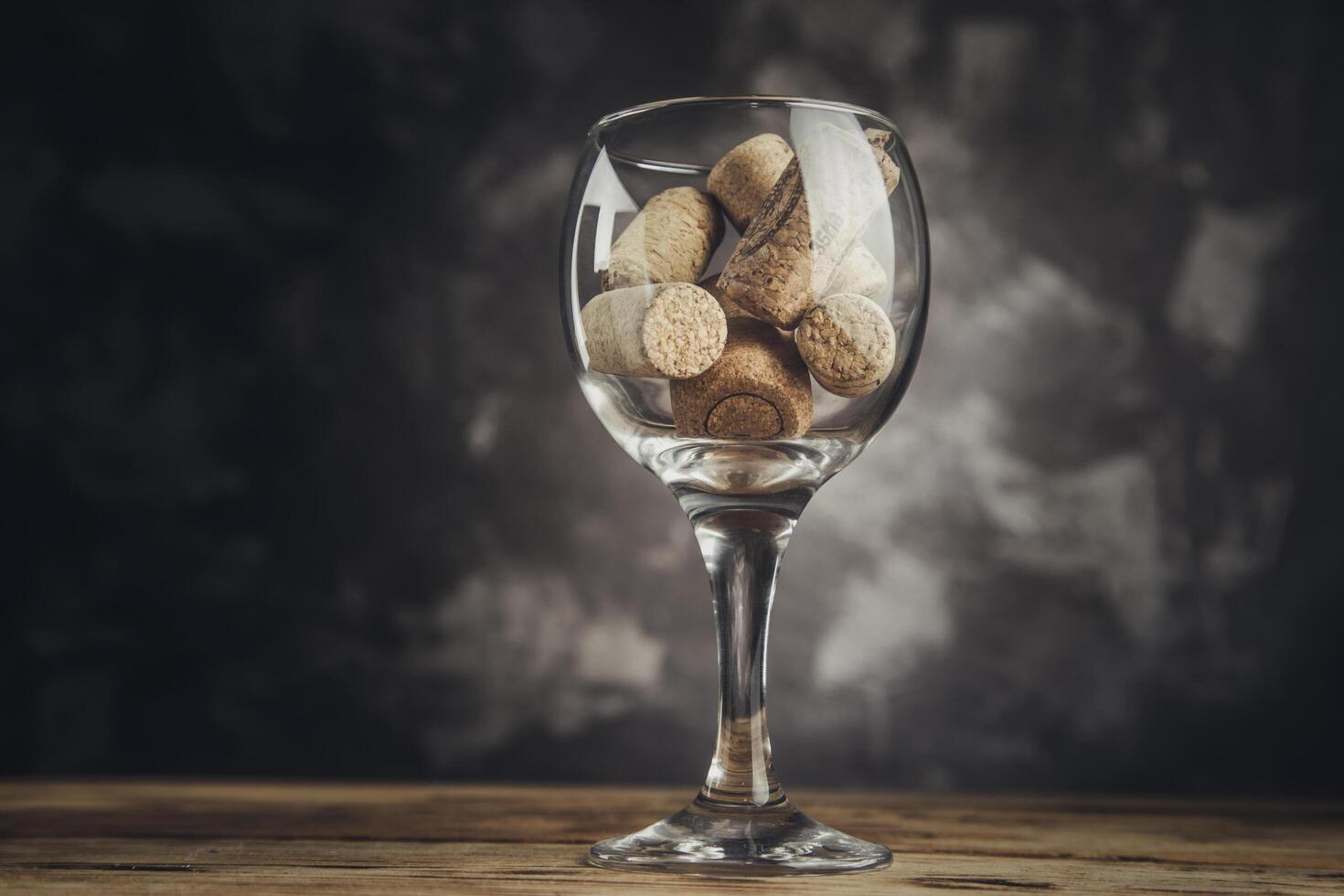 Wine corks in a glass on table photo