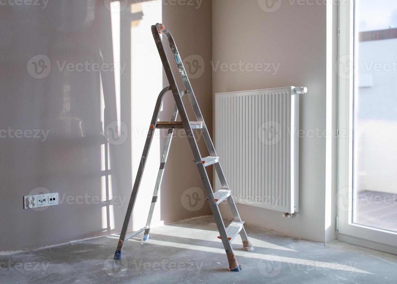 Empty room of new building during reconstruction. Stepladder in construction site inside apartment during repair works. photo