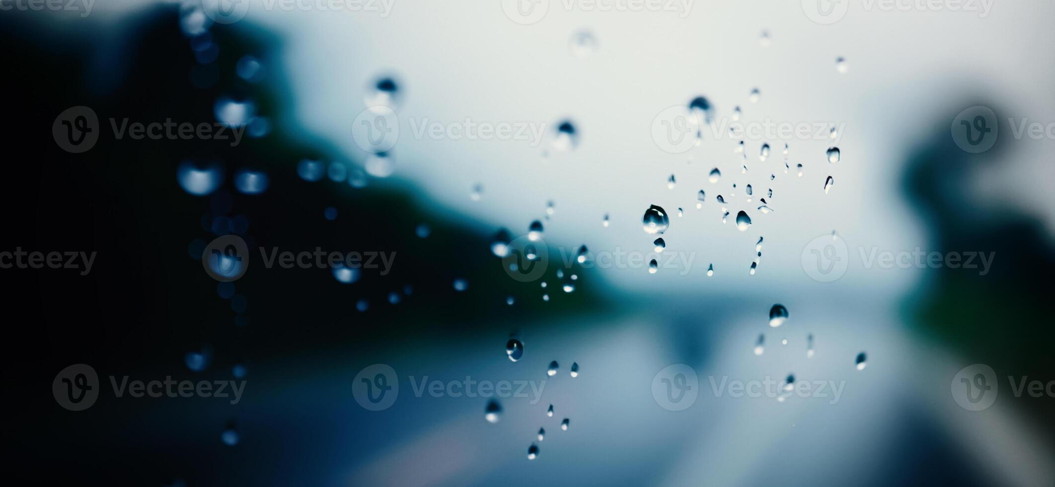 Rain shower on car windshield car window and blurry road in background. photo
