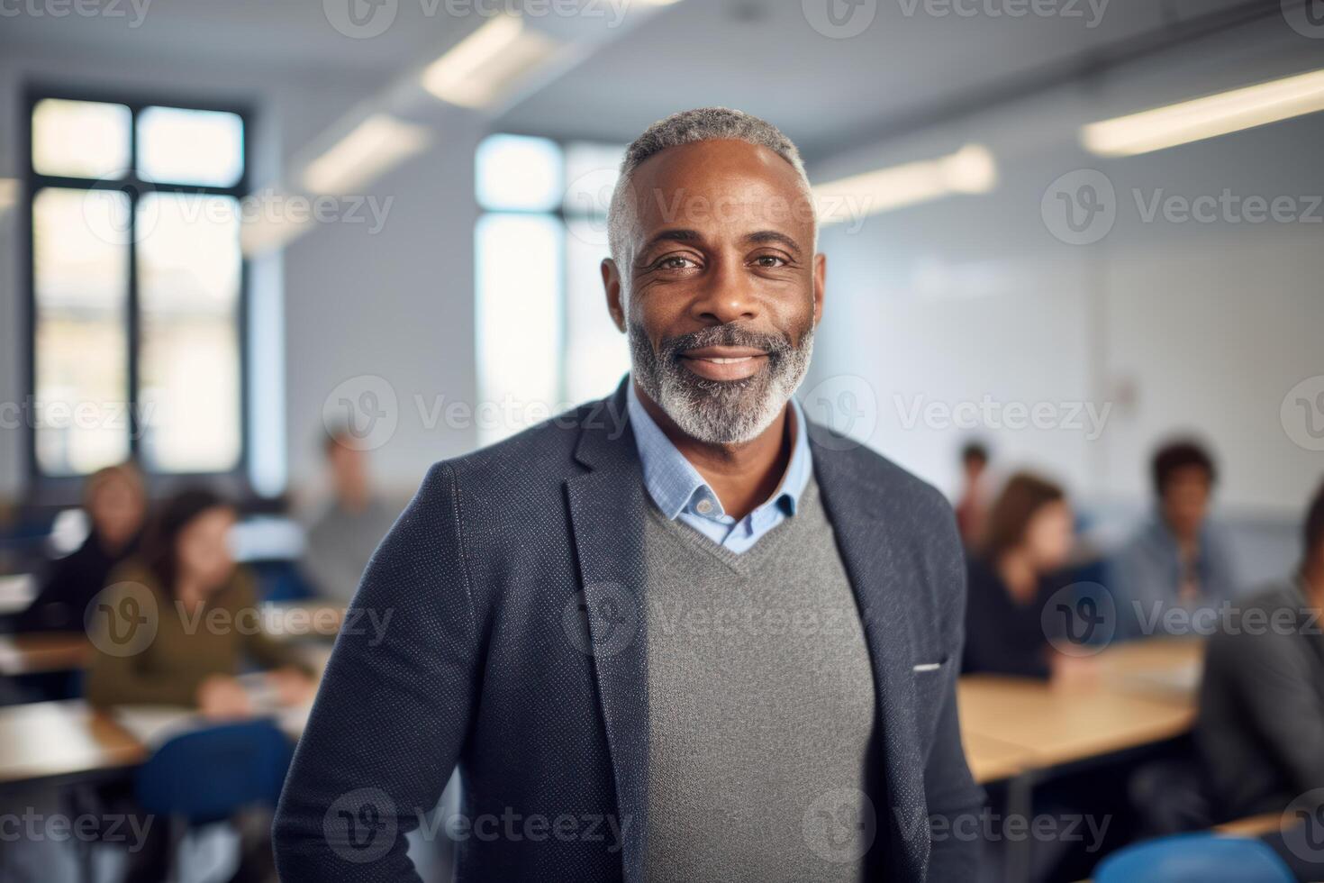 Smiling professor standing in classroom with students studying, photo