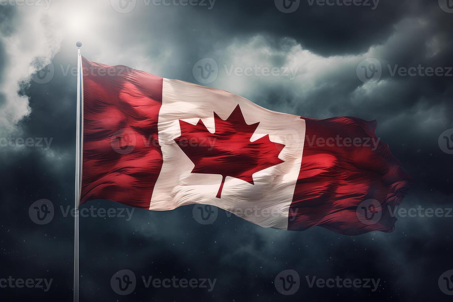Canadian flag waving under dramatic sky at night photo