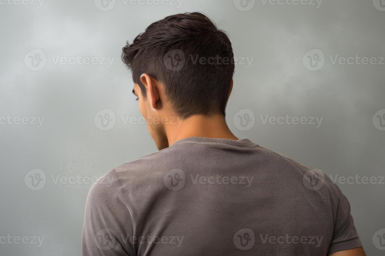 Young man turning back while looking over his shoulder photo