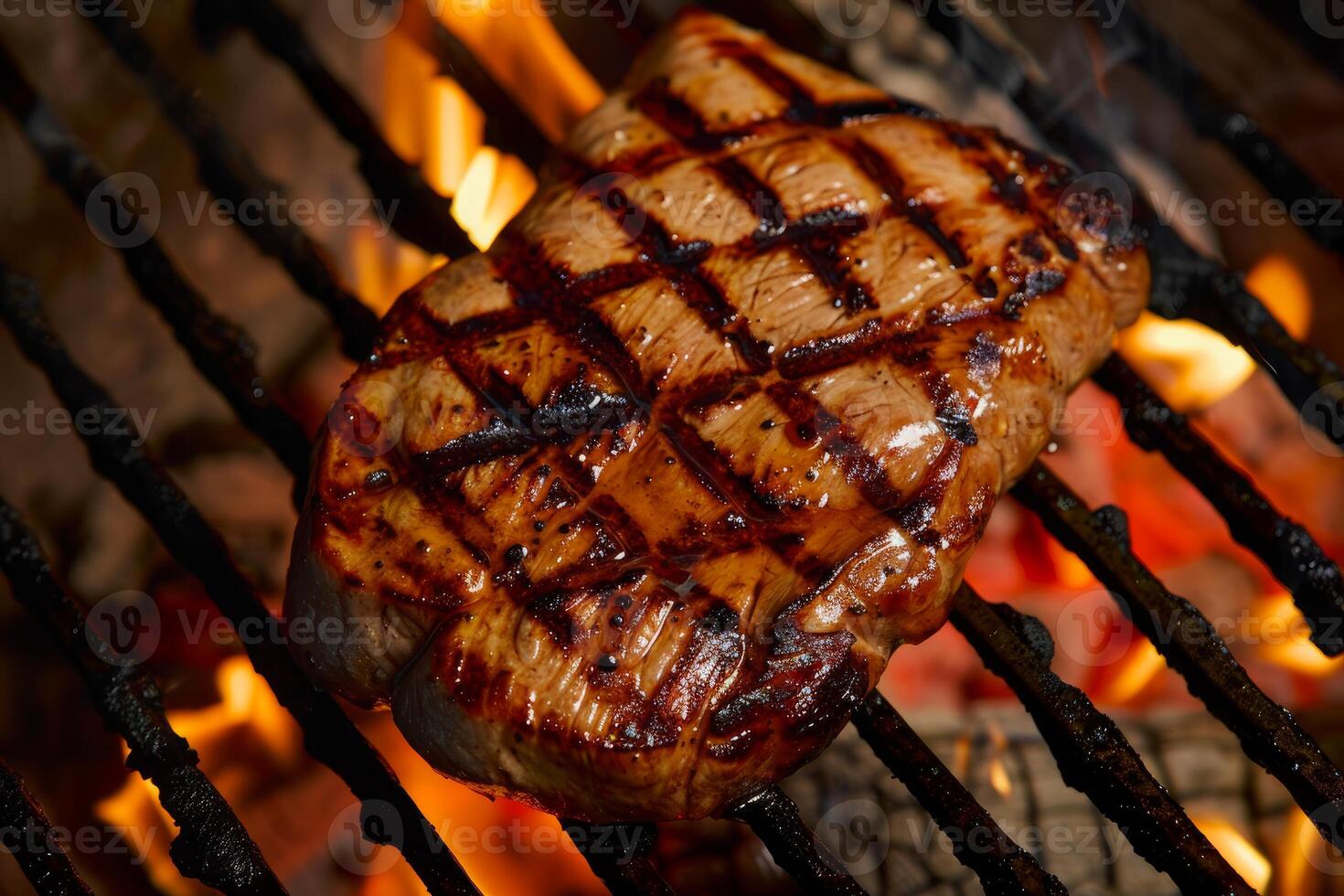 Grilled steak cooking on hot flaming grill with sear marks photo