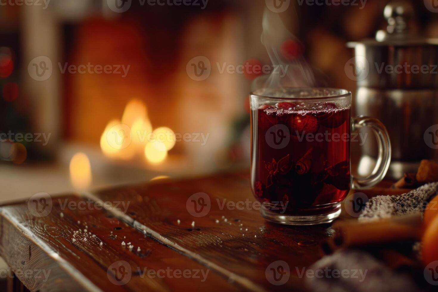 Steaming mulled wine with cranberries and spices on wooden table by fireplace during christmas time photo