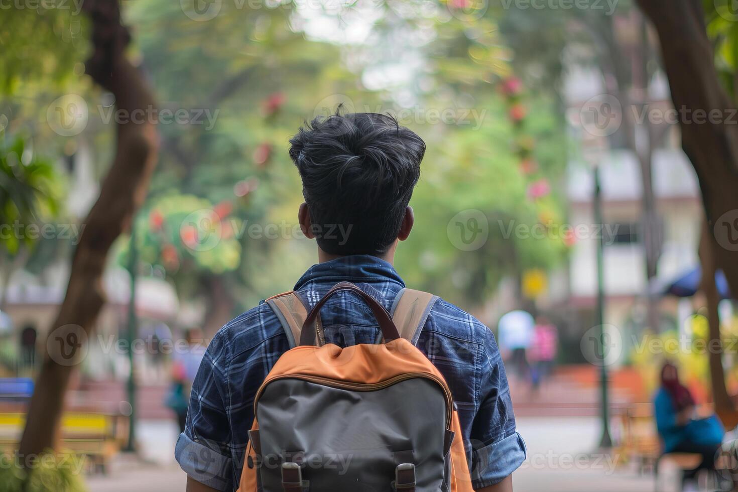 Student walking on campus looking towards university building photo