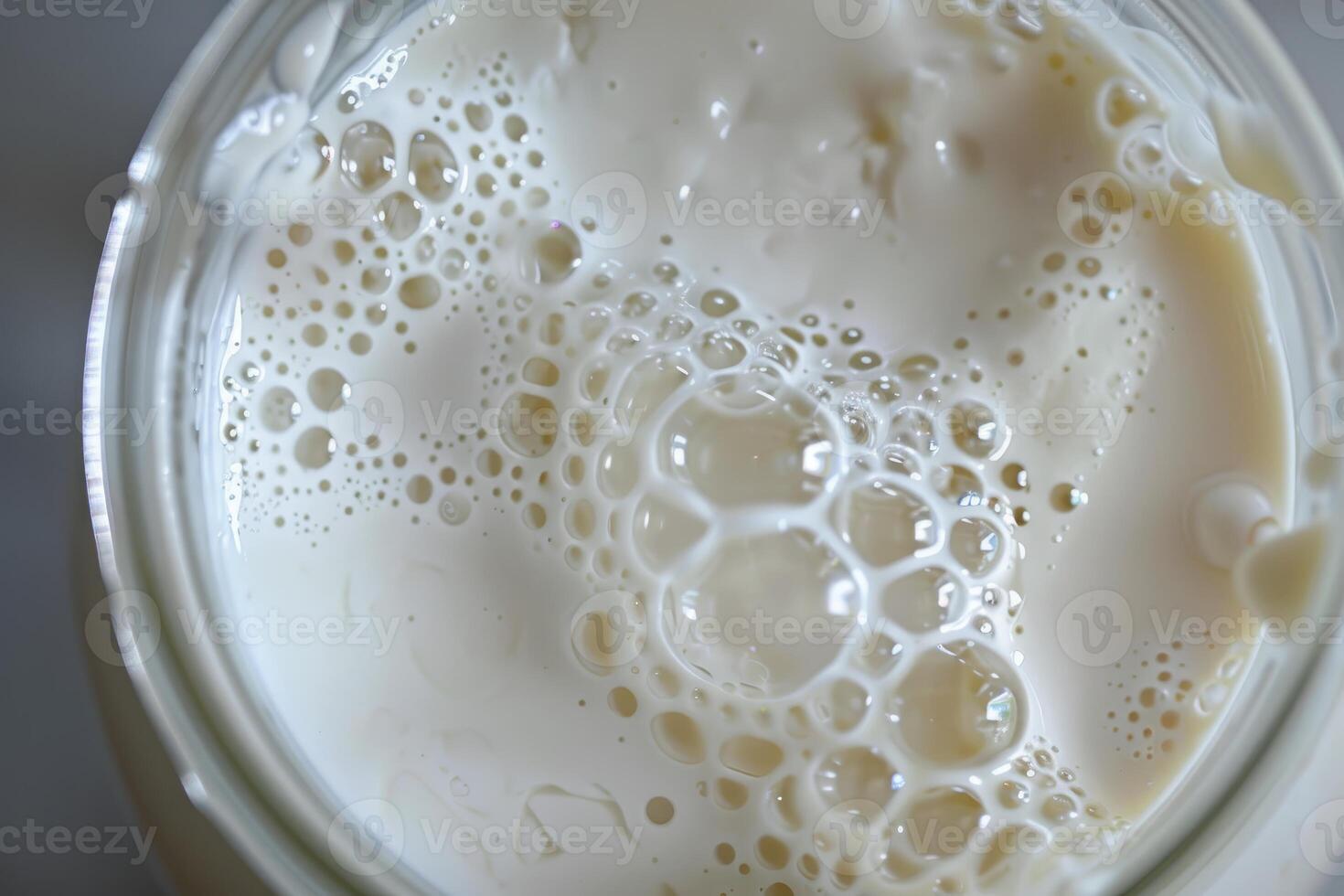 Milk with bubbles creating interesting patterns in glass jar photo