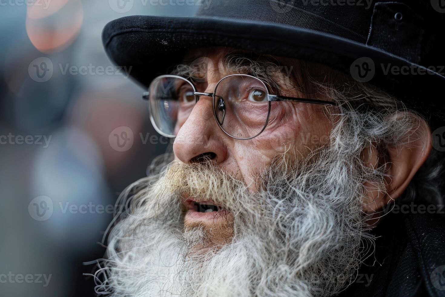 Bearded senior man wearing a hat and glasses is looking upwards photo