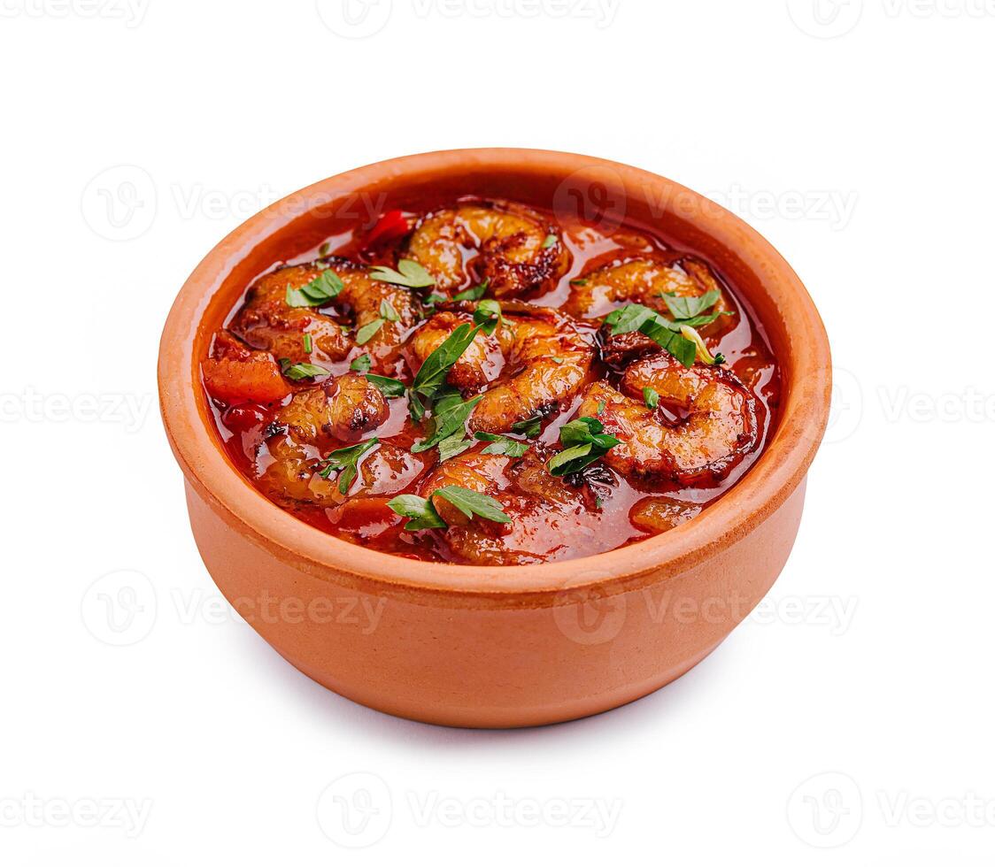 Delicious shrimp dish in a clay pot garnished with fresh herbs and spices photo
