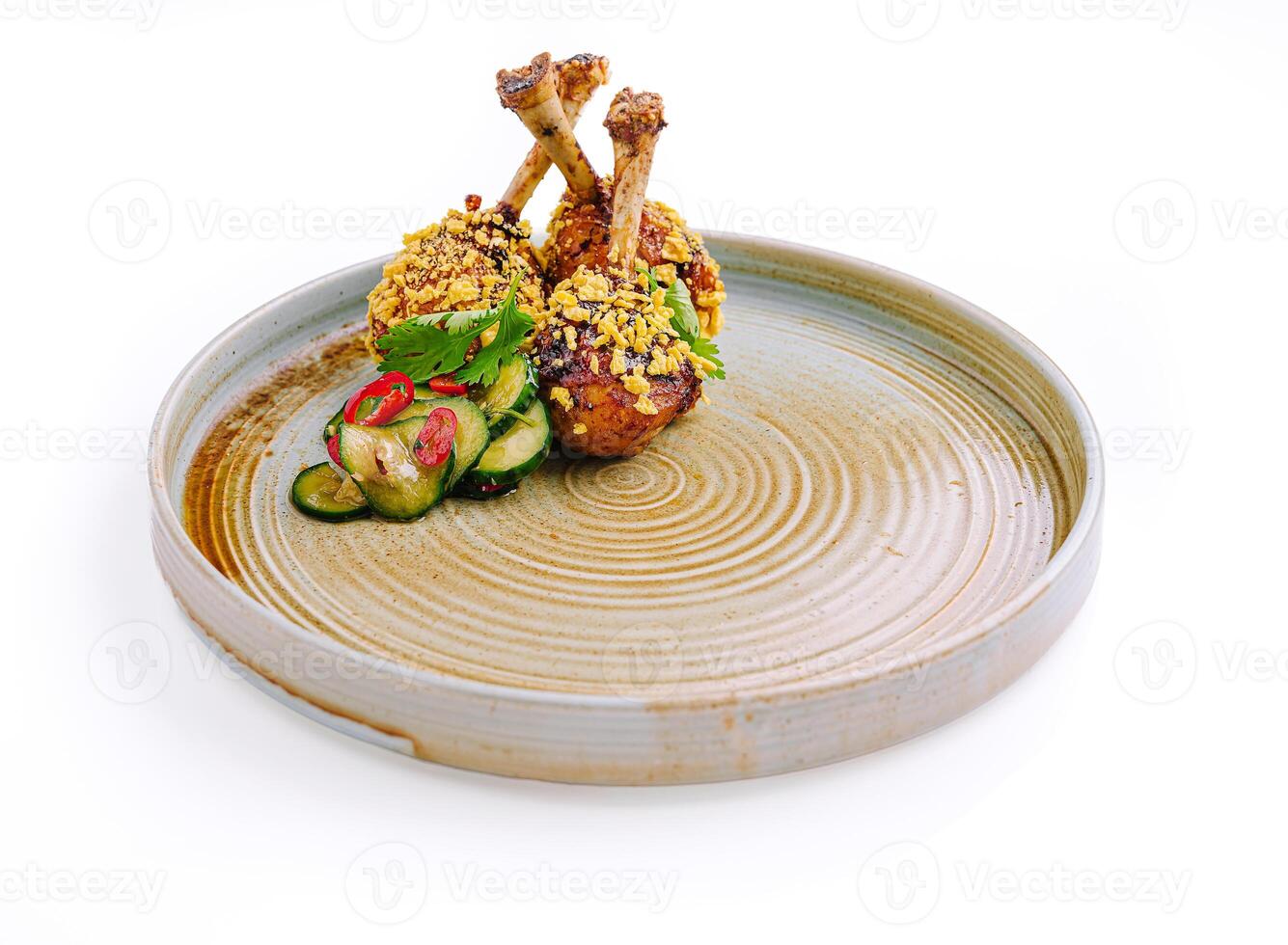 Deliciously plated chicken drumsticks with crunchy coating and refreshing cucumber salad on a rustic dish photo