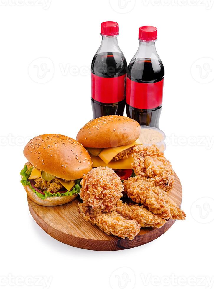 Delicious meal with fried chicken, cheese burgers, and soft drinks served on a wooden platter photo
