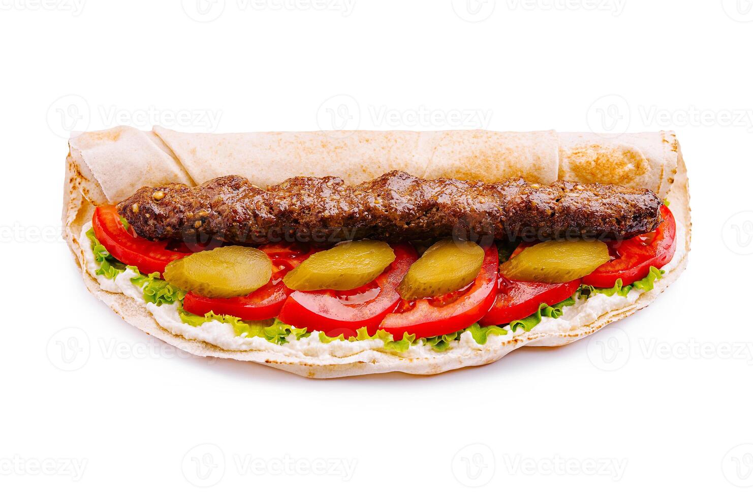 Delicious kebab wrap with fresh vegetables and sauce served on a flatbread photo