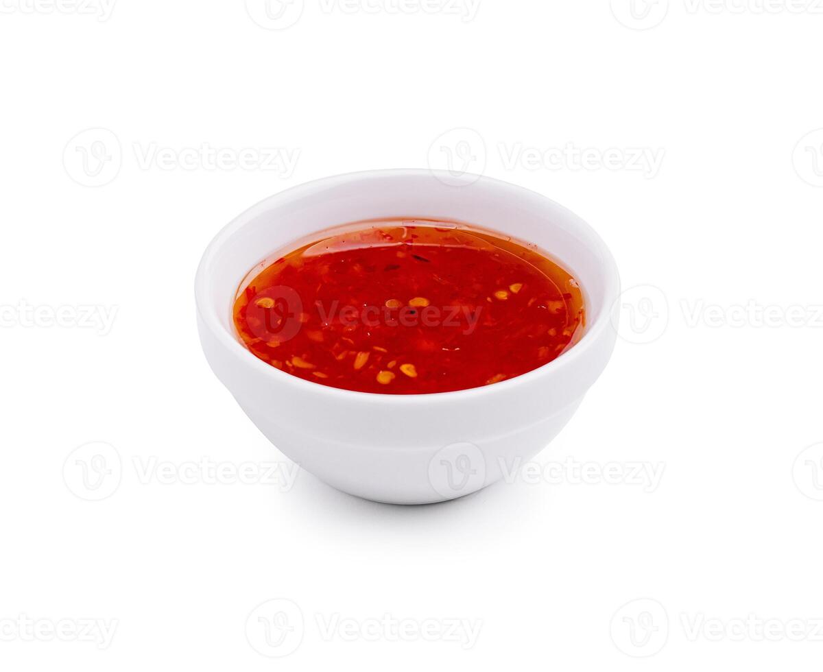 Tangy red dipping sauce in a white bowl on a plain background, perfect for appetizers or snacks photo