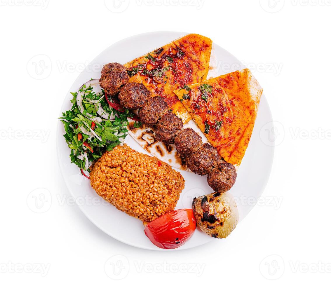 Grilled kebabs served with spicy flatbread, rice, and fresh salad on a plate in a vibrant setting photo