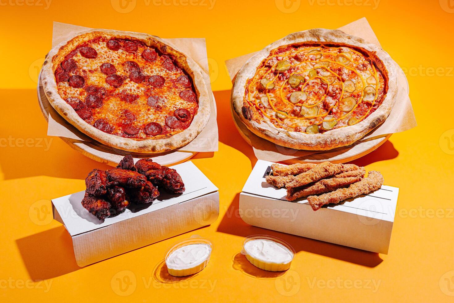 Delightful spread of pizza and wings on a vibrant orange background, perfect for sharing during a casual gathering photo