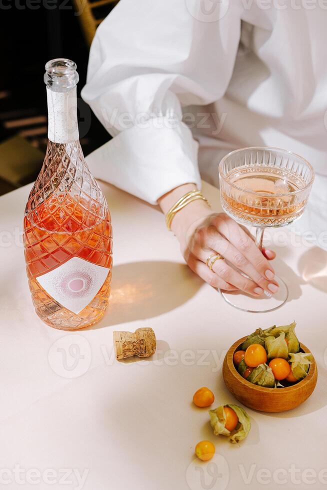 Elegant drink presentation with rose-colored beverage and fresh accompaniments on a dining table photo