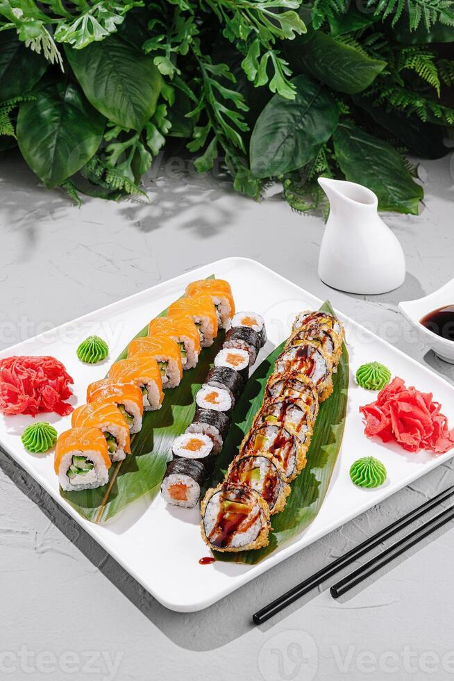 Delicious sushi platter featuring various rolls and garnishes served on a white plate photo