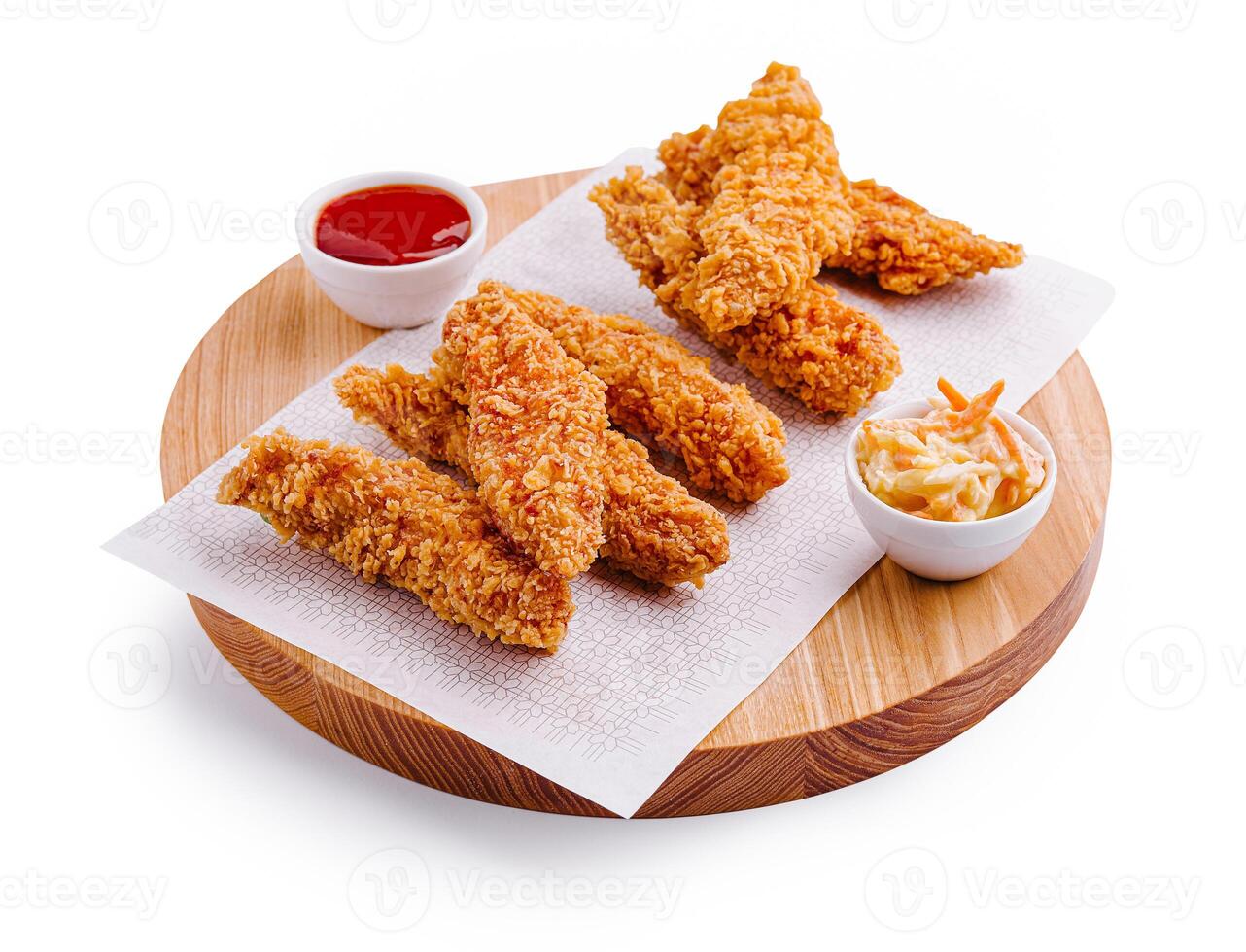 Crispy fried chicken tenders served with dipping sauce and coleslaw on a wooden platter at a casual dining setting photo