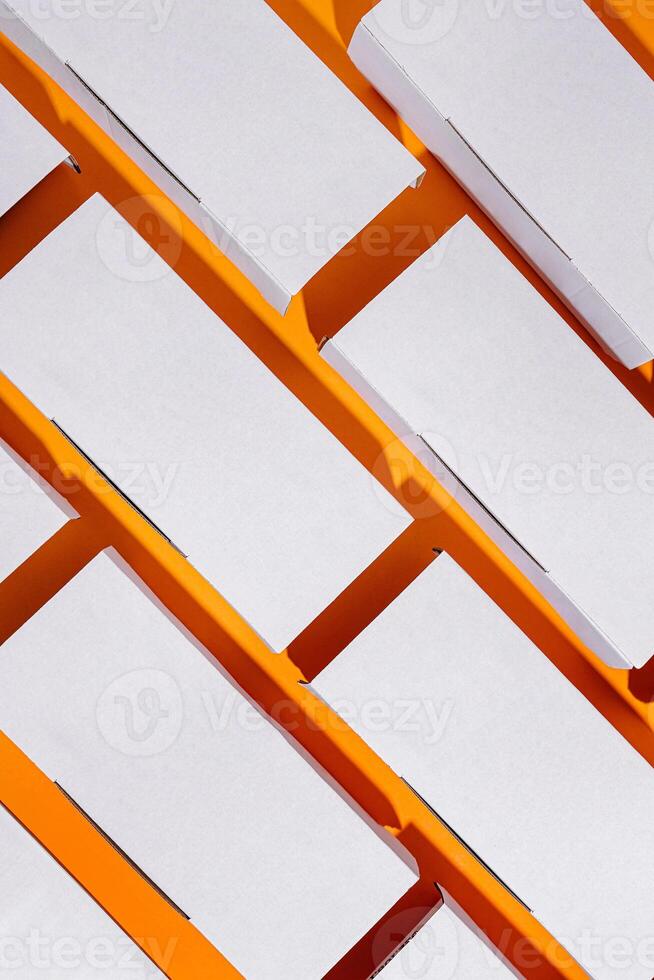 Colorful arrangement of blank packaging boxes on an orange background in a well-lit workspace photo
