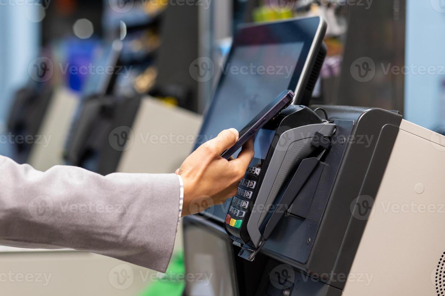 Closeup image showcasing a person using a smartphone for contactless payment at a point of sale terminal in a retail store. The concept convenience increasing usage of mobile payment methods. photo