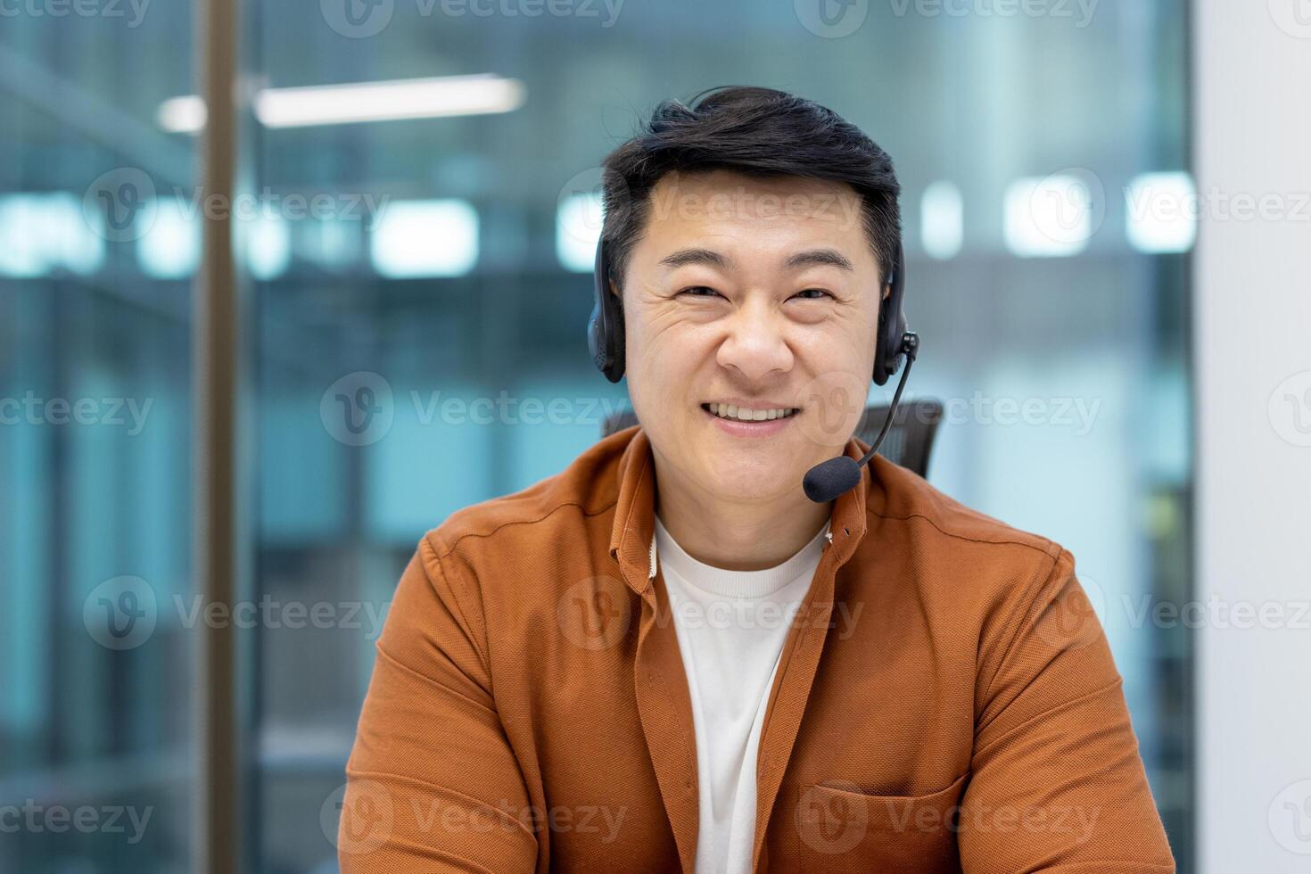 Asian man mature businessman wearing a headset and smiling confidently in a professional work setting, illustrating customer service, communication, and modern office environments. photo