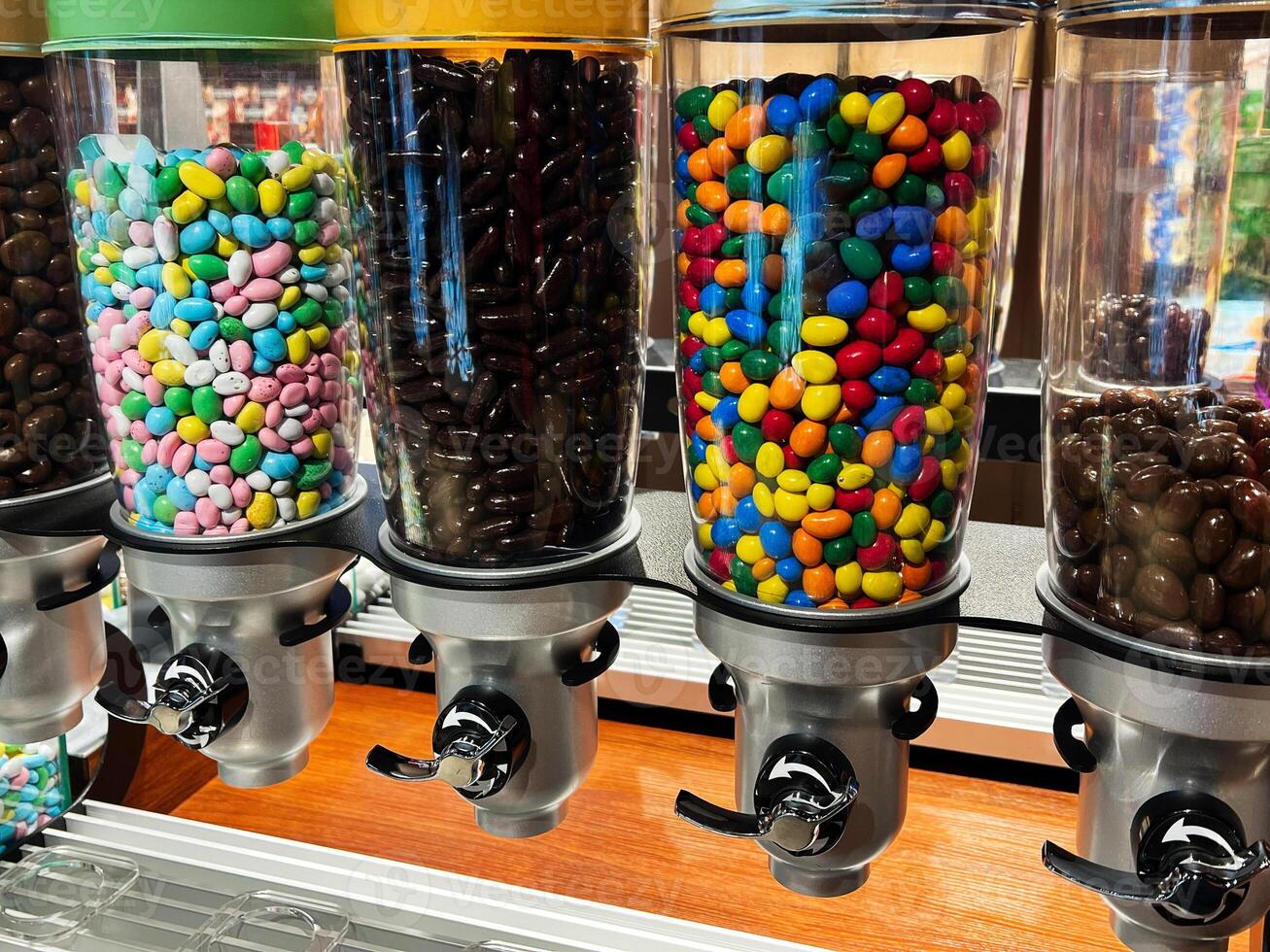 Colorful candy dispensers showcasing assorted sweets and chocolates in a shop display photo