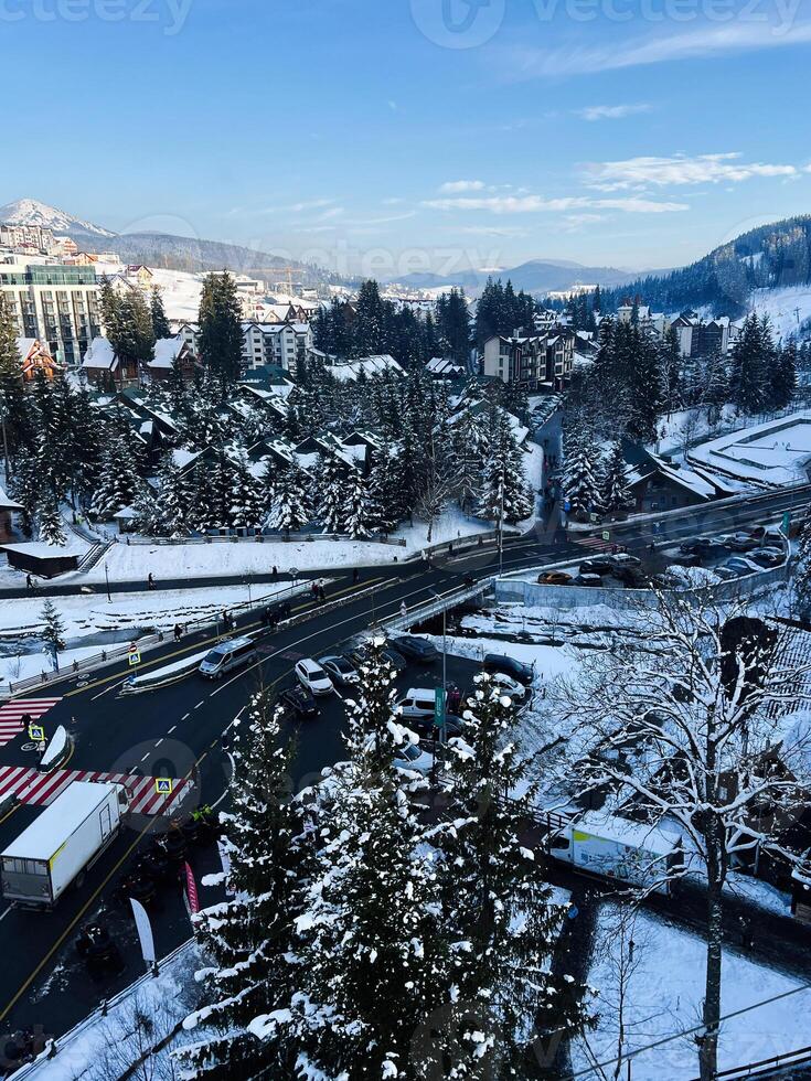 Snowy urban scene featuring buildings, trees, and roads in a winter landscape photo