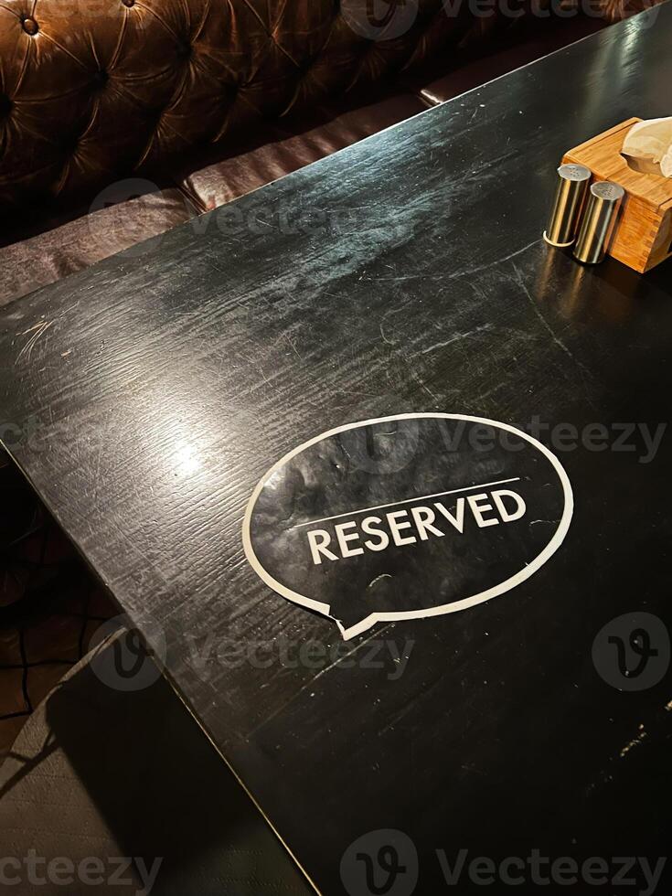 Reserved table with elegant leather seating in a cozy restaurant setting photo
