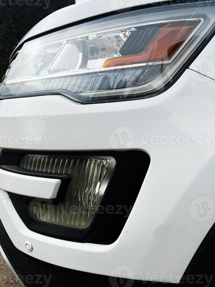 Close-up view of modern white car headlight and front grille design photo