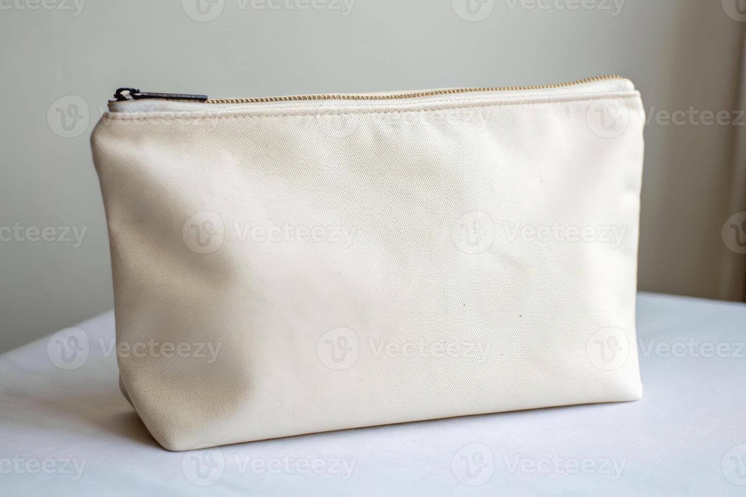 Soft zippered off-white pouch close-up view minimalist design indoor setting simple aesthetic photo