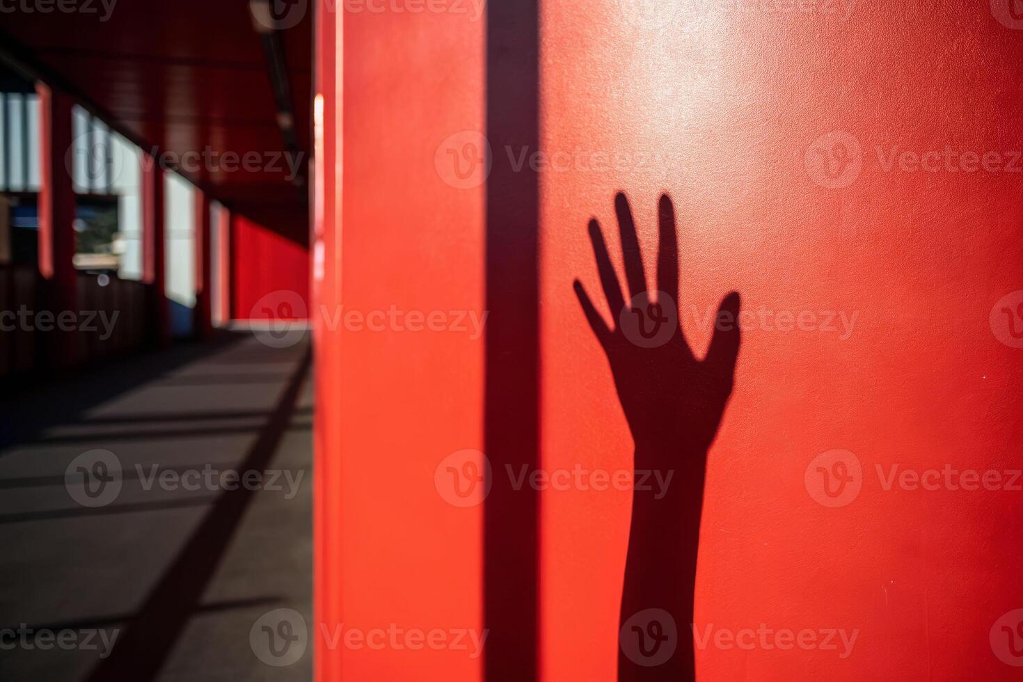 Death shadow cast by hand reaching across red wall in urban hallway symbolizing life's transience photo