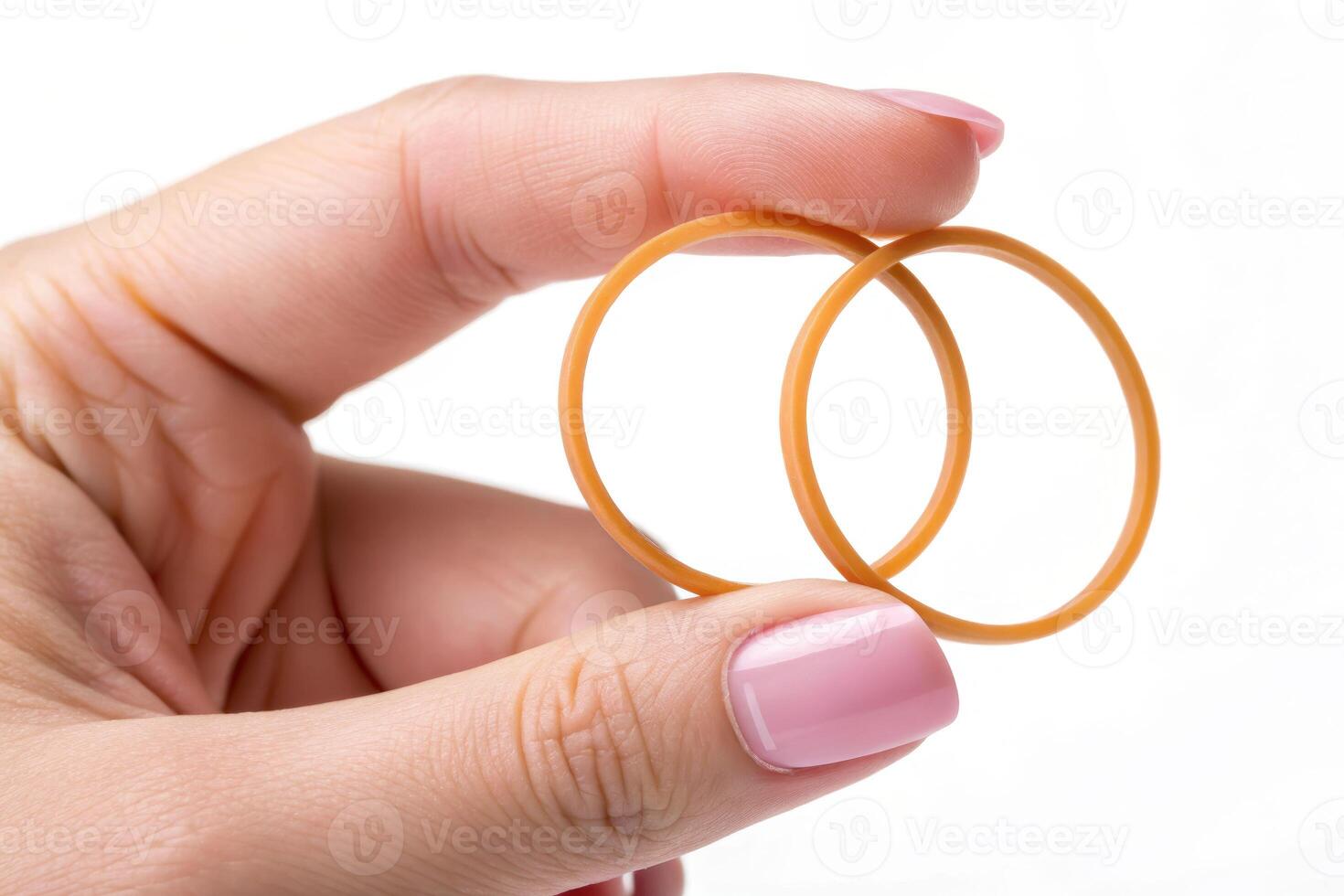 Close-up view of a fair-skinned hand holding two rubber bands studio setting material concept minimalist environment photo