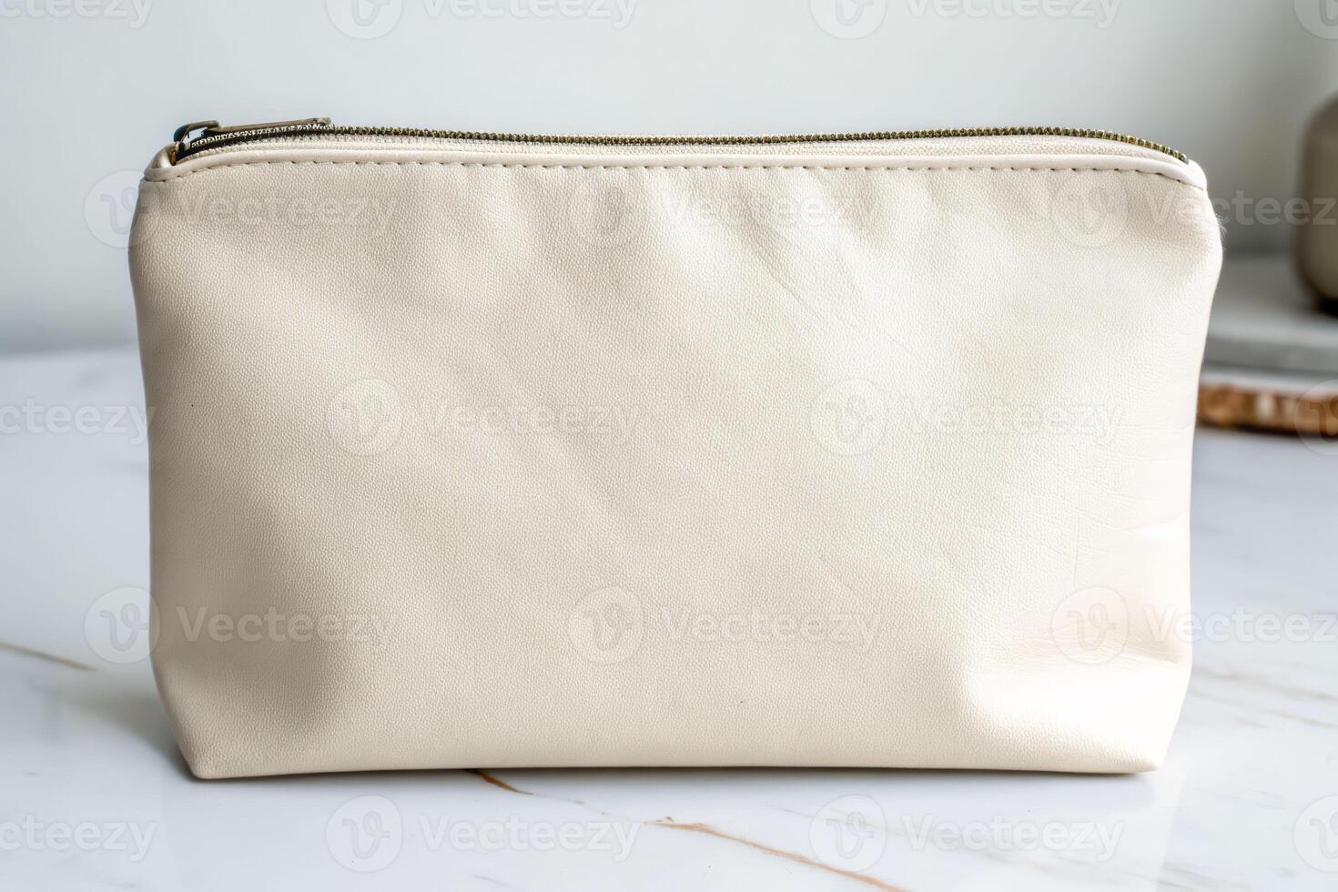 Soft close-up view of a blank off-white zippered pouch on marble surface minimalist design modern aesthetic photo
