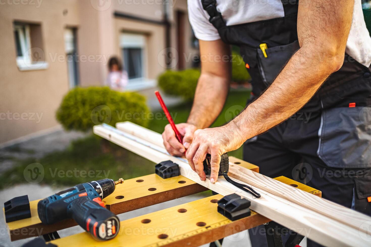 Unrecognizable men measuring wooden plank outdoors photo