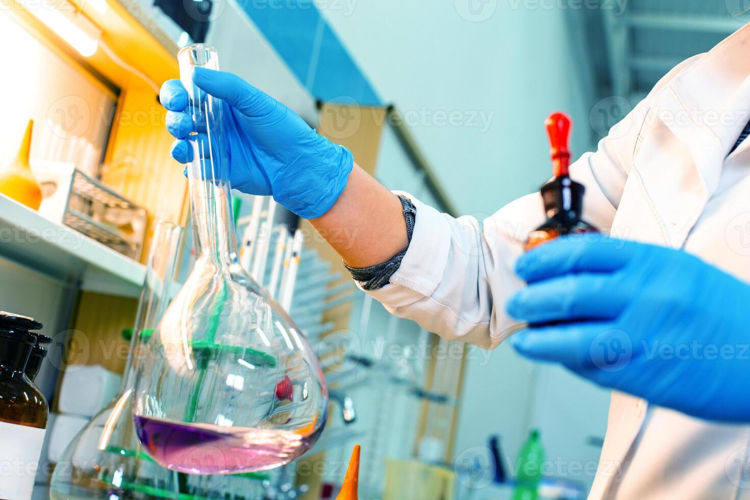 Researcher conducts chemical experiment with flask and reagent in laboratory setting photo