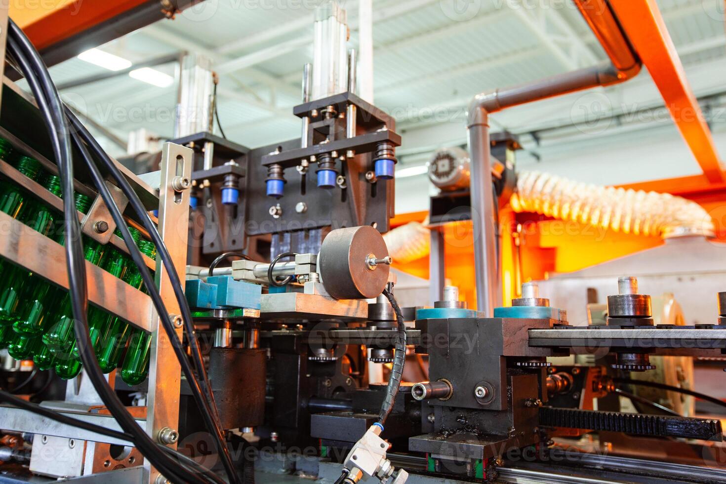 Industrial machinery operates on production line for bottle filling and capping in a modern factory setting photo