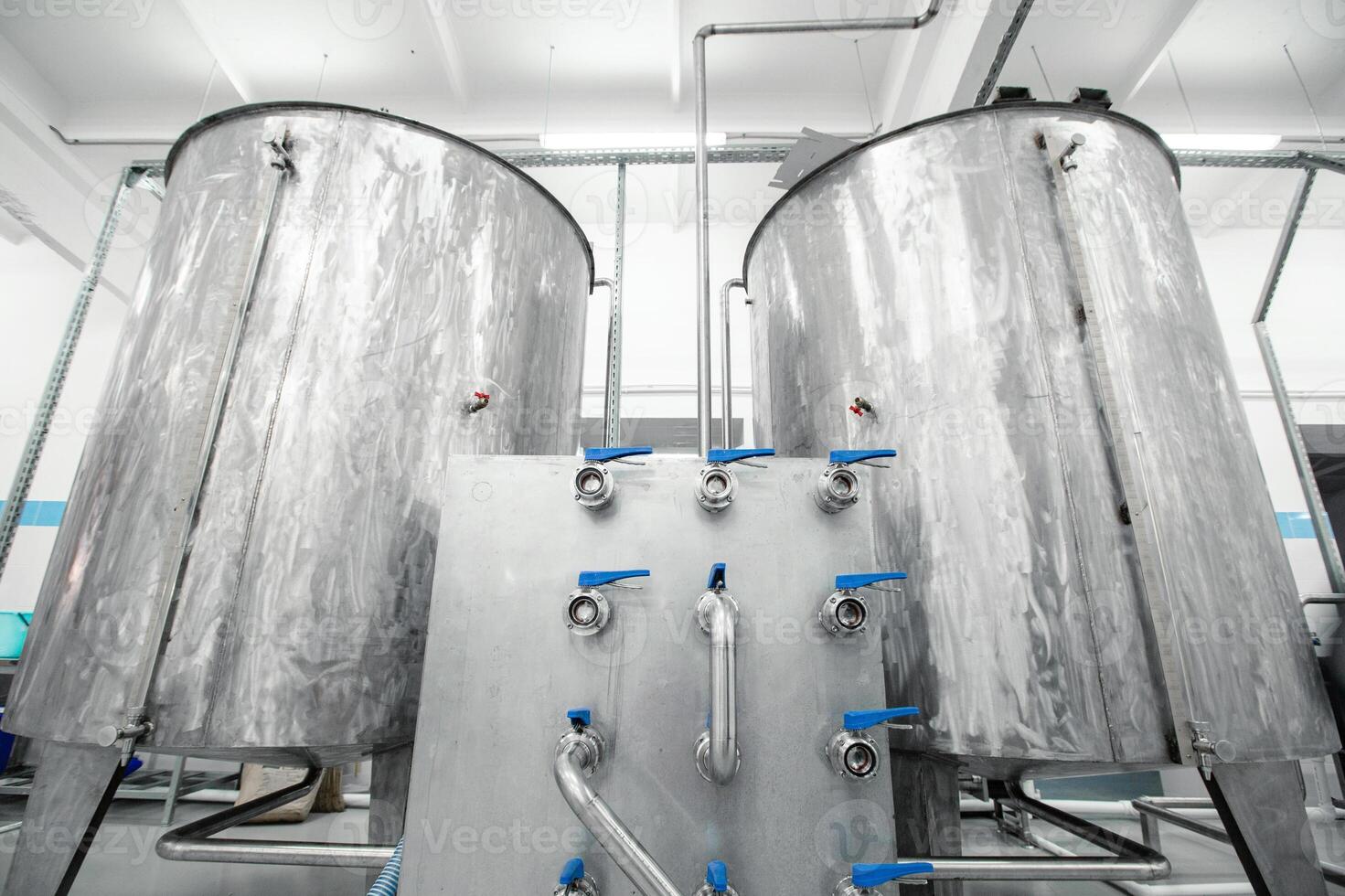 Metallic fermentation tanks in a brewery showcasing industrial design and equipment in an operational facility photo