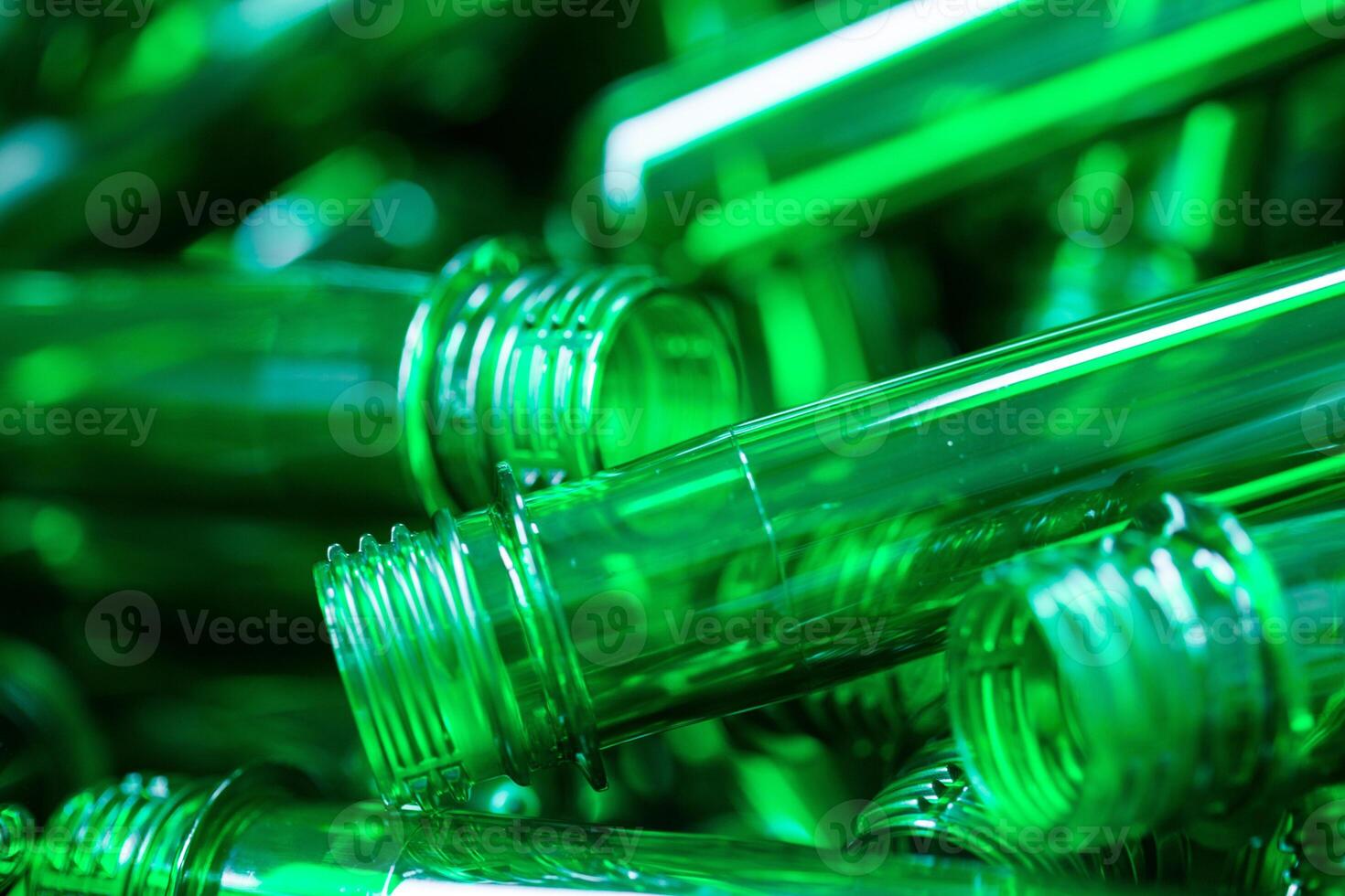 Green glass bottles stacked together in a bright display during a recycling event in an urban area photo
