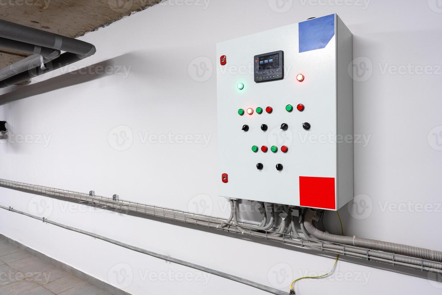 Control panel mounted on wall in a modern industrial facility with various buttons and indicators photo