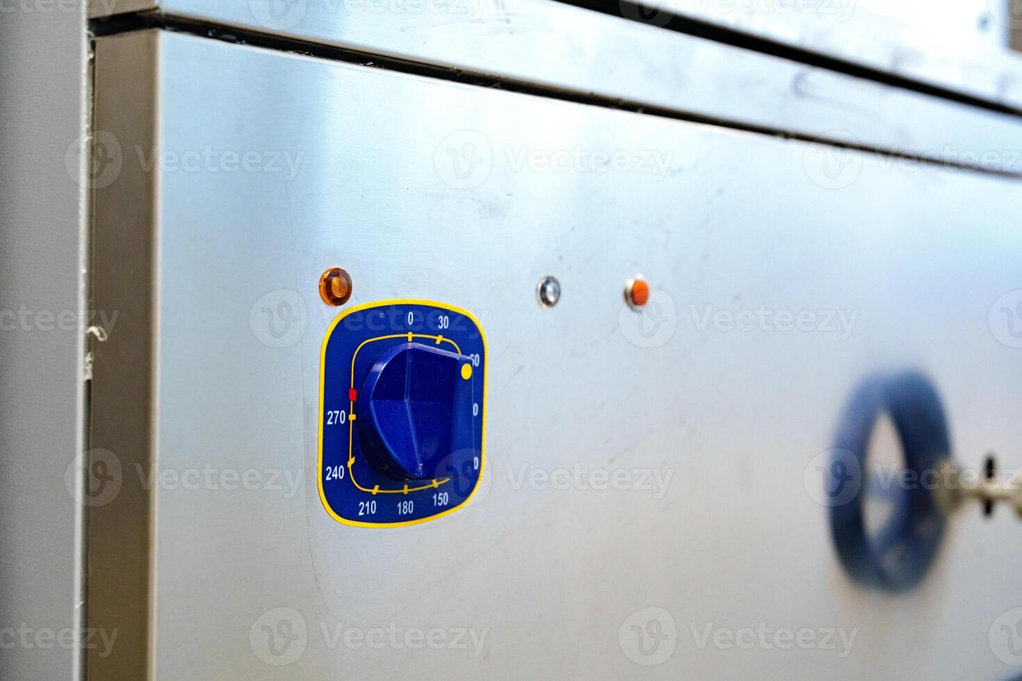 Dial control on a stainless steel kitchen appliance with indicator lights during food preparation activity photo