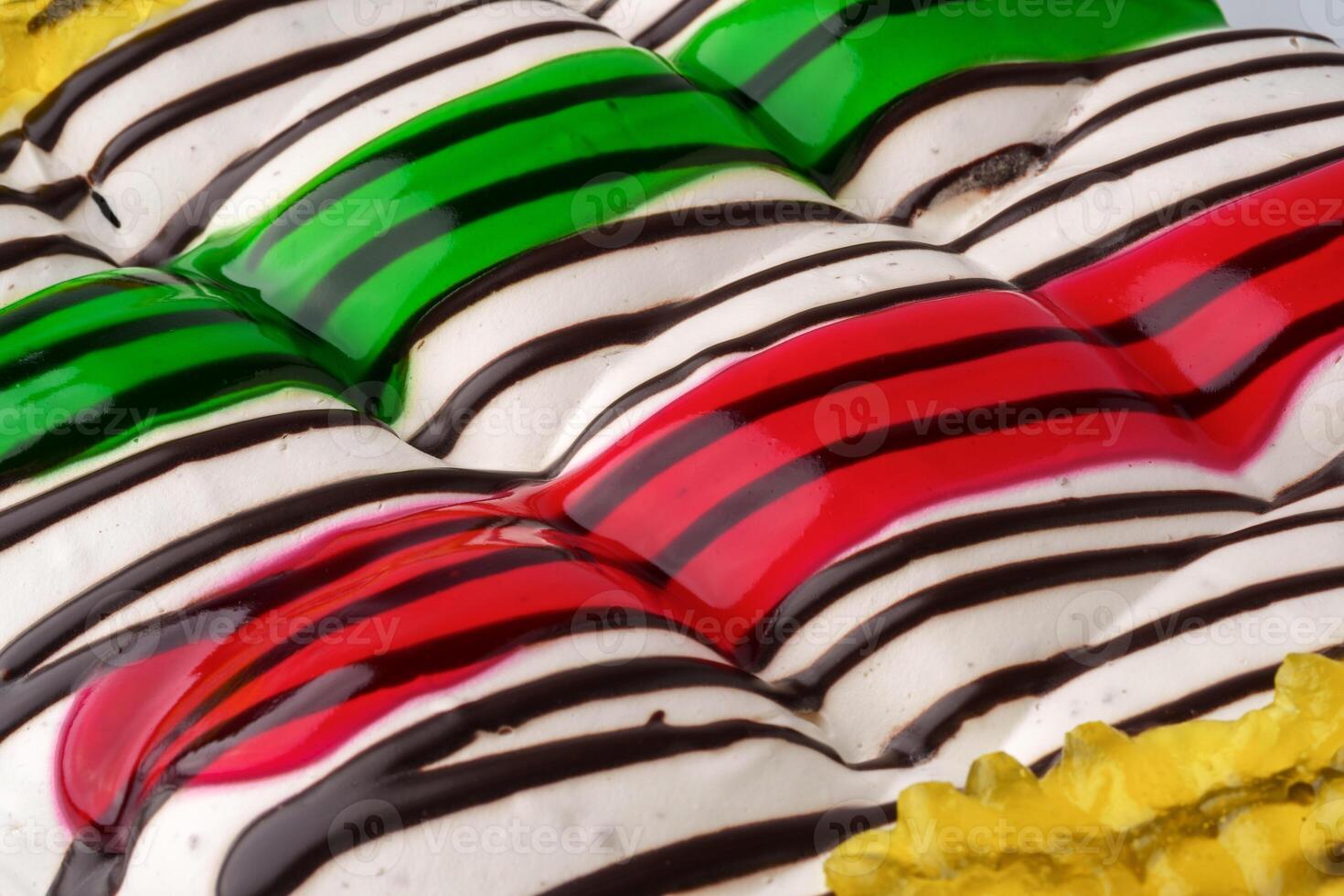 Colorful dessert with layers of cream and vibrant fruit jelly on a textured surface photo
