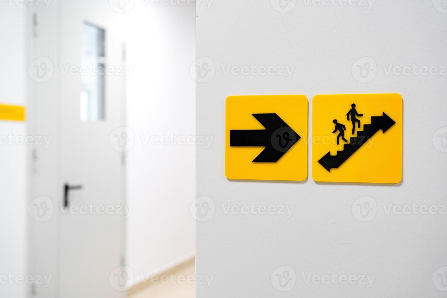 Directional signs indicate stairway and exit in a modern building hallway photo