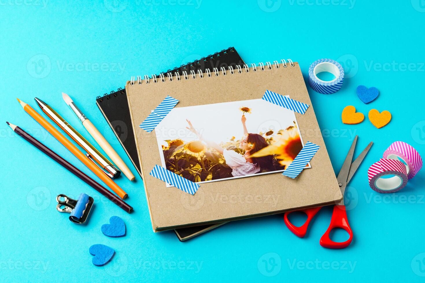 Crafting a scrapbook on a vibrant blue background with various supplies and materials photo