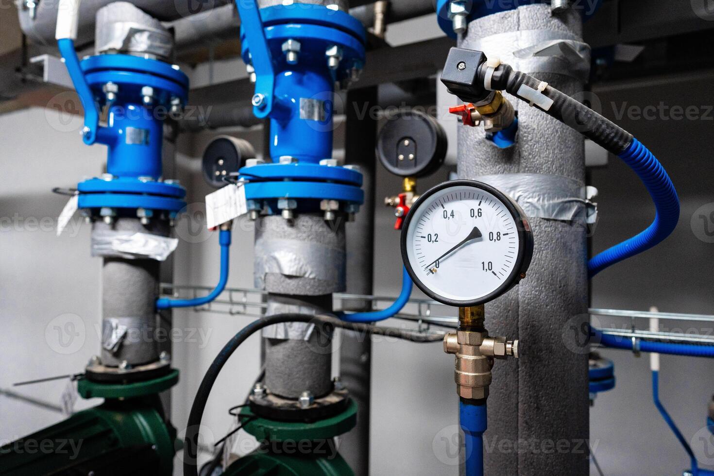 Industrial plumbing setup with pressure gauge and valves in a commercial space photo