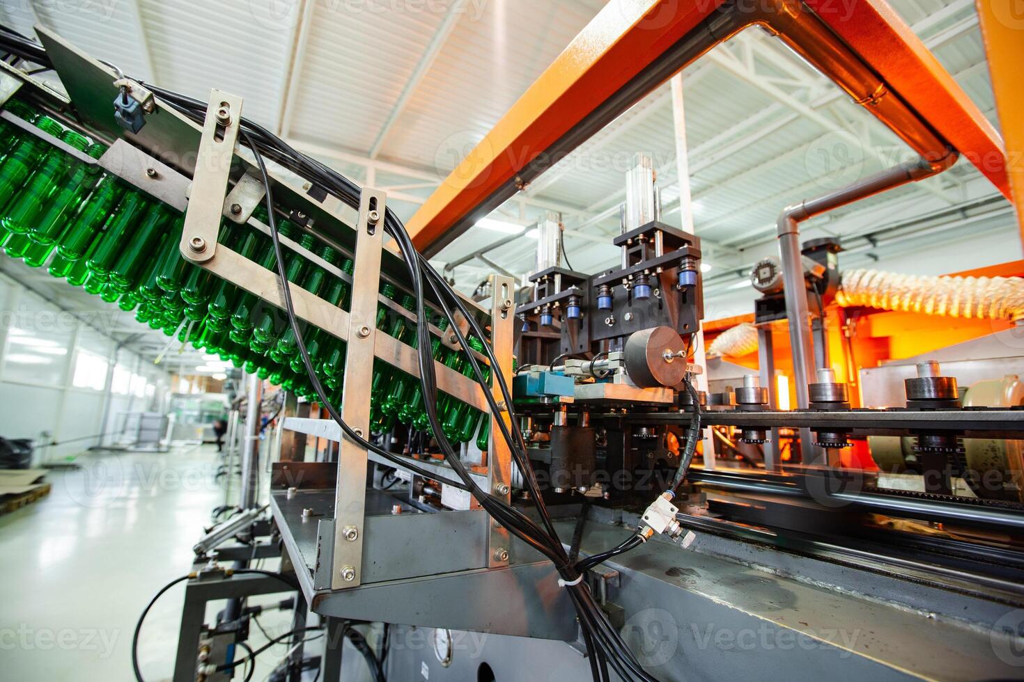 Bottling line in a factory showcasing machinery and green bottles in production photo
