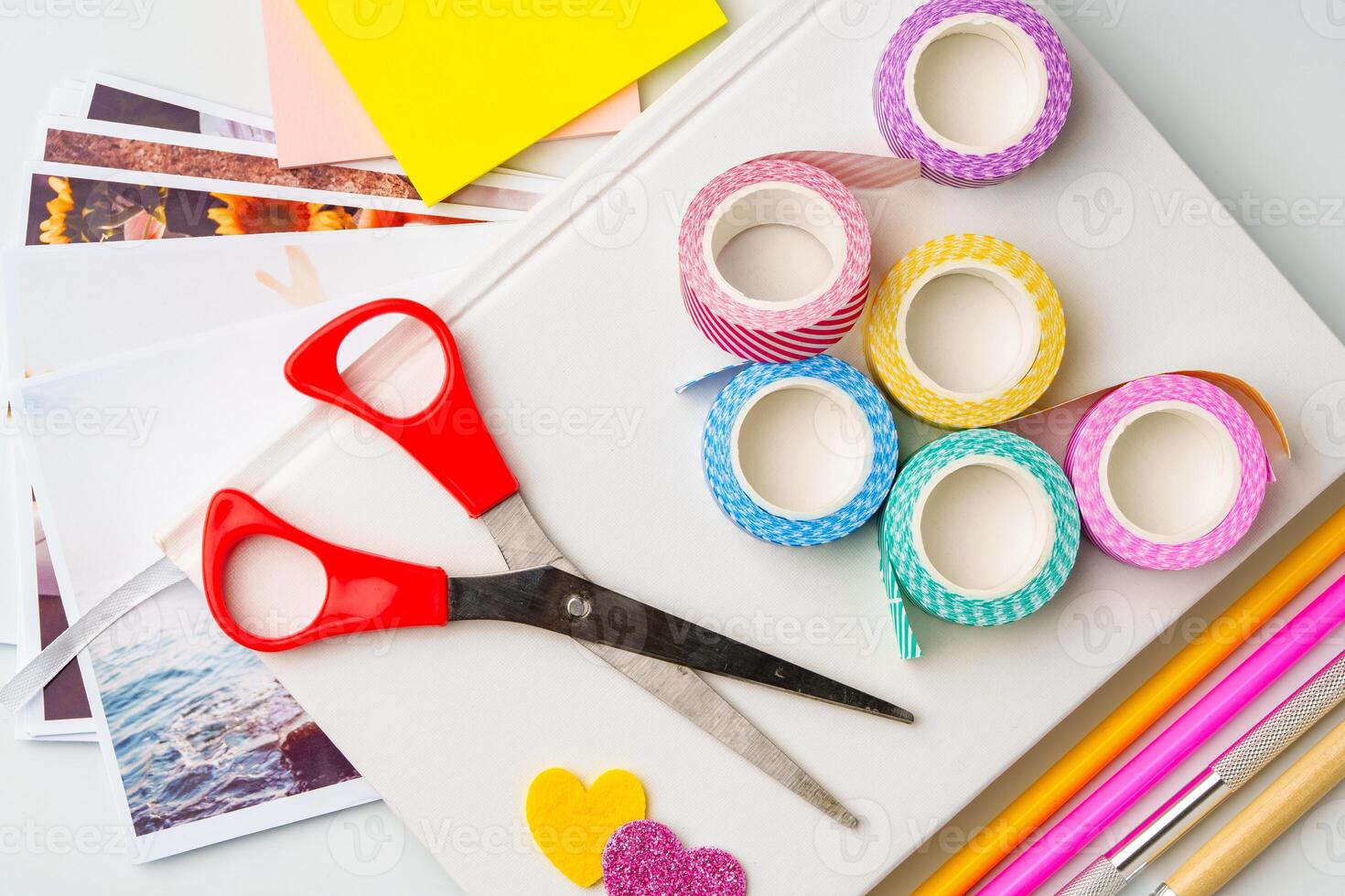 Crafting materials spread on a table for creative projects with scissors, washi tape, and colored paper photo
