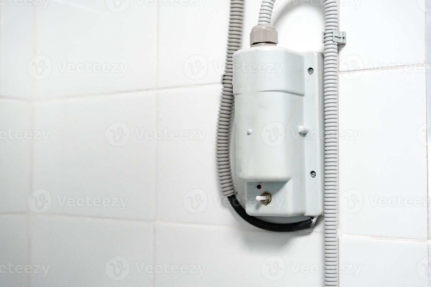 Electric shower unit mounted on tiled bathroom wall showing design features and installation details photo